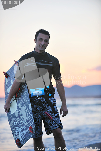Image of Portrait of a young  kitsurf  man at beach on sunset