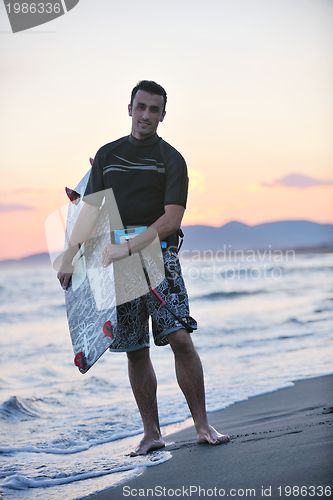 Image of Portrait of a young  kitsurf  man at beach on sunset