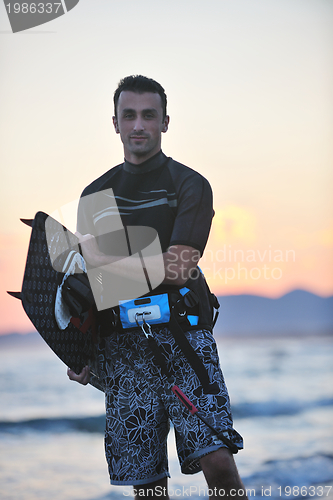 Image of Portrait of a young  kitsurf  man at beach on sunset