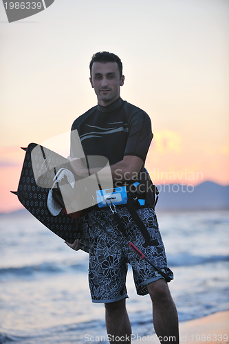 Image of Portrait of a young  kitsurf  man at beach on sunset