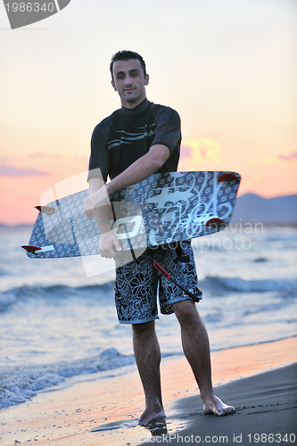 Image of Portrait of a young  kitsurf  man at beach on sunset