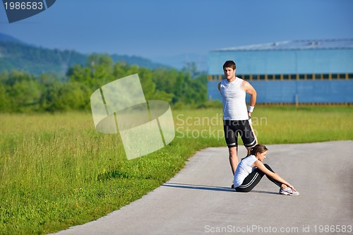 Image of people doing stretching exercise  after jogging