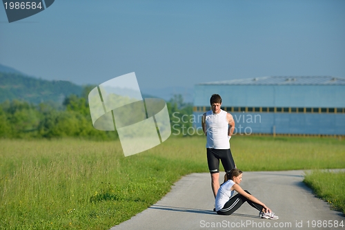 Image of people doing stretching exercise  after jogging
