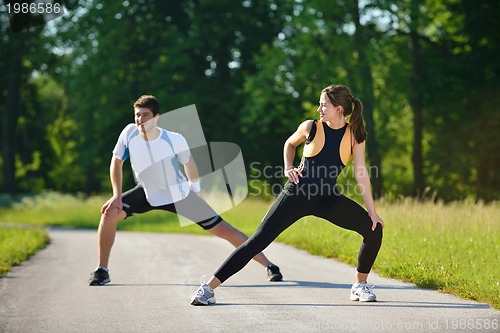 Image of people doing stretching exercise  after jogging
