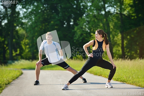 Image of people doing stretching exercise  after jogging