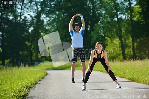 Image of people doing stretching exercise  after jogging