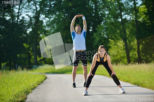 Image of people doing stretching exercise  after jogging