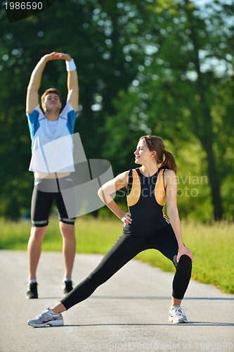 Image of people doing stretching exercise  after jogging