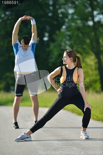 Image of people doing stretching exercise  after jogging