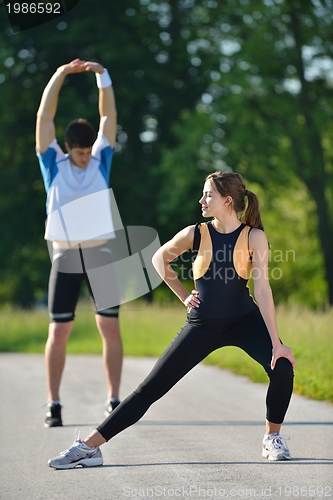 Image of people doing stretching exercise  after jogging