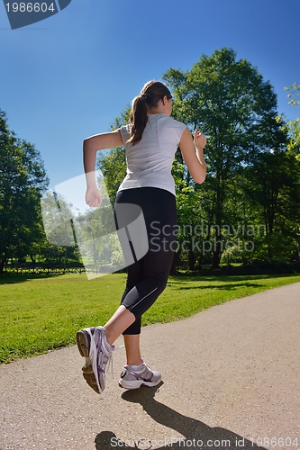 Image of Young beautiful  woman jogging at morning in park