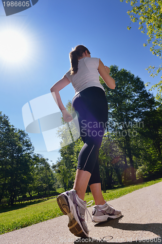 Image of Young beautiful  woman jogging at morning in park