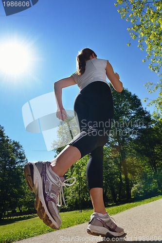 Image of Young beautiful  woman jogging at morning in park