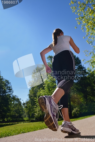 Image of Young beautiful  woman jogging at morning in park