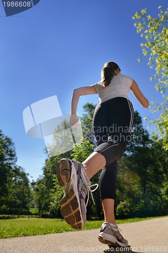 Image of Young beautiful  woman jogging at morning in park