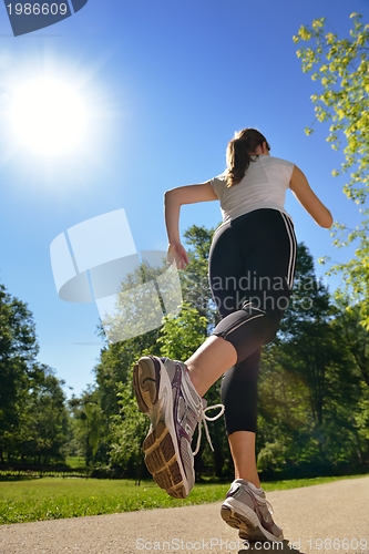 Image of Young beautiful  woman jogging at morning in park