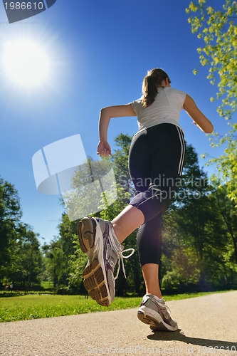 Image of Young beautiful  woman jogging at morning in park