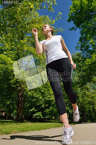 Image of Young beautiful  woman jogging at morning in park