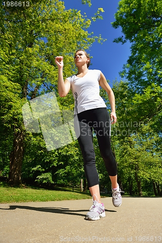 Image of Young beautiful  woman jogging at morning in park