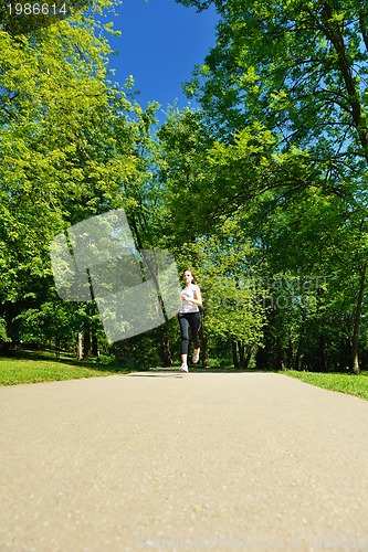 Image of Young beautiful  woman jogging at morning in park