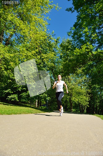 Image of Young beautiful  woman jogging at morning in park
