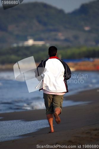 Image of man jogging at beach 
