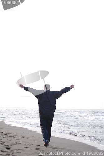 Image of man jogging at beach 