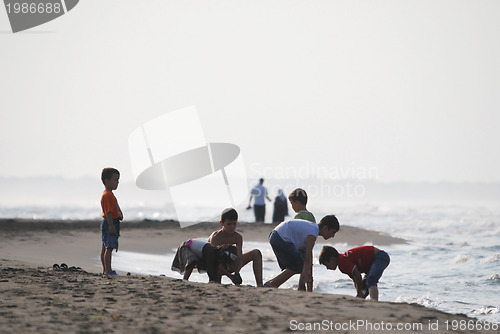Image of childs having fun on beach at early morning