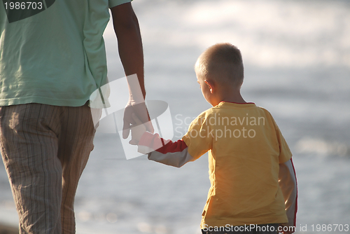 Image of father and son walking on beach