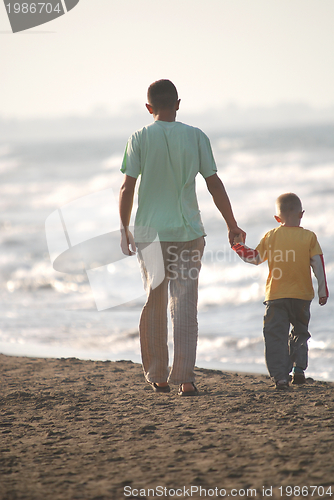 Image of father and son walking on beach