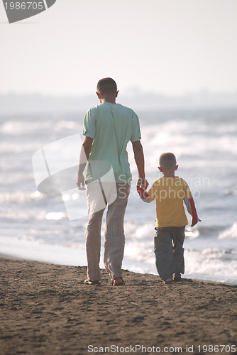 Image of father and son walking on beach