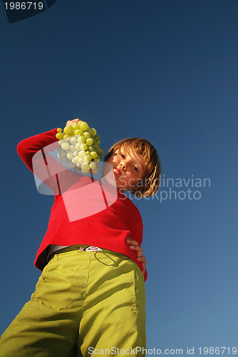 Image of happy girl with grape outside