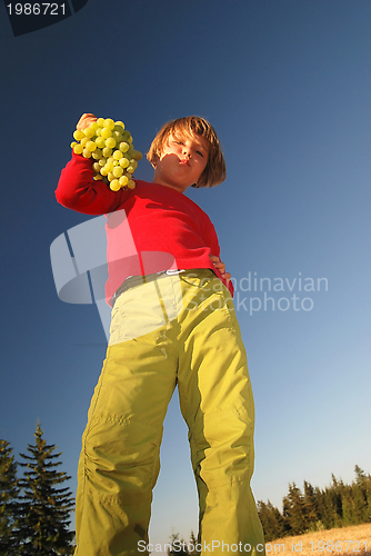 Image of happy girl with grape outside
