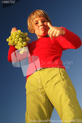 Image of happy girl with grape outside