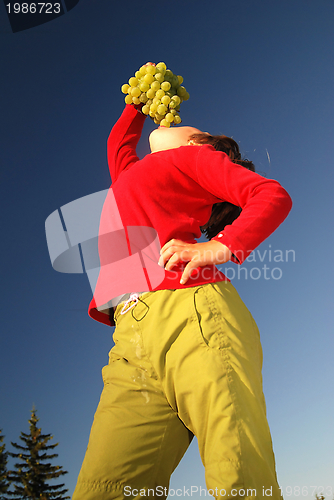 Image of happy girl with grape outside