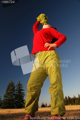 Image of happy girl with grape outside