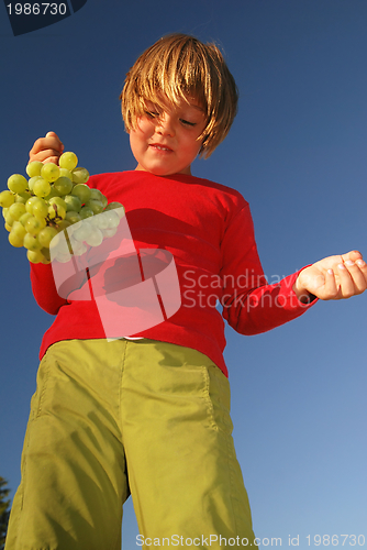 Image of happy girl with grape outside