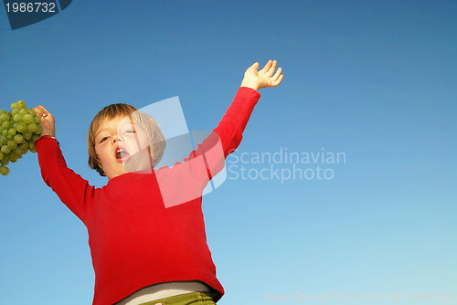 Image of girl with grape outdoor