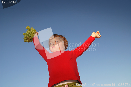 Image of girl with grape outdoor