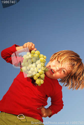Image of happy girl with grape outside
