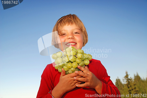 Image of happy girl with grape outside