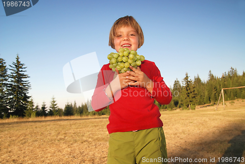 Image of happy girl with grape outside