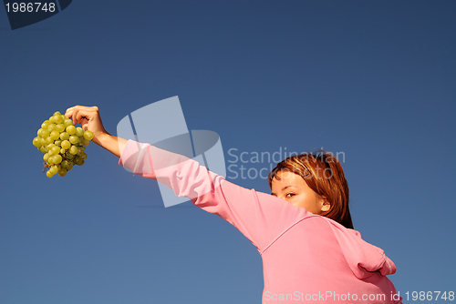 Image of girl with grape outdoor