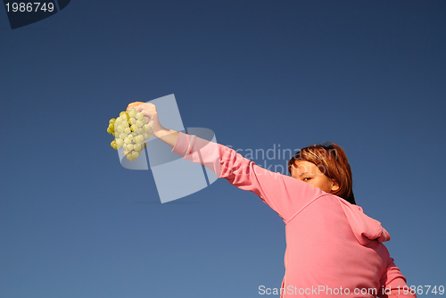 Image of girl with grape outdoor