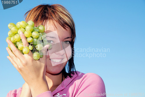 Image of girl with grape outdoor