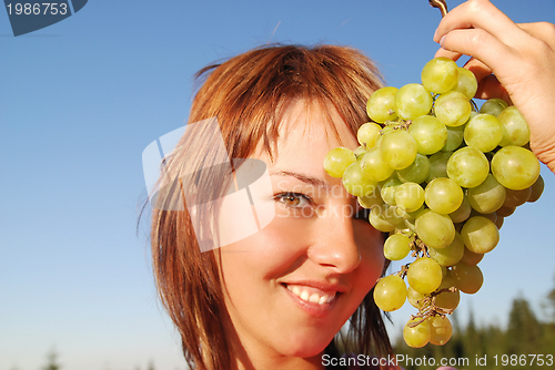 Image of girl with grape outdoor