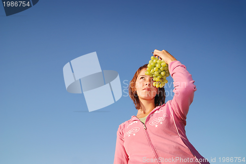 Image of girl with grape outdoor