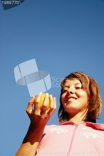 Image of beautyful girl throwing orange in air