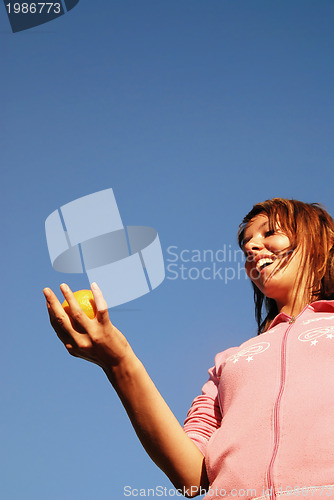 Image of beautyful girl throwing orange in air