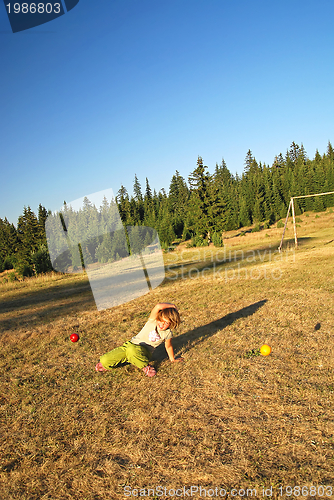 Image of happy girl throwing apple outside